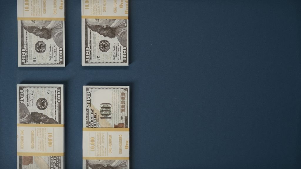 403b vs 401k: Key Differences Explained Four US banknotes arranged on a dark background
