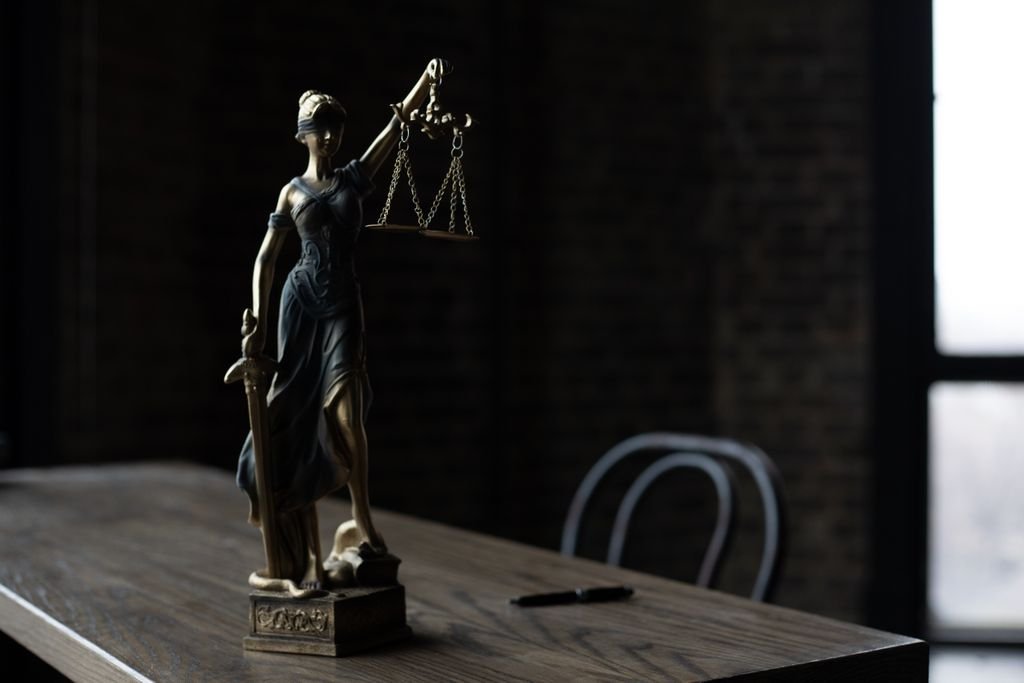 Power of Attorney vs. Guardianship: Key Differences, Costs and Control Statue holding scales of justice on a table