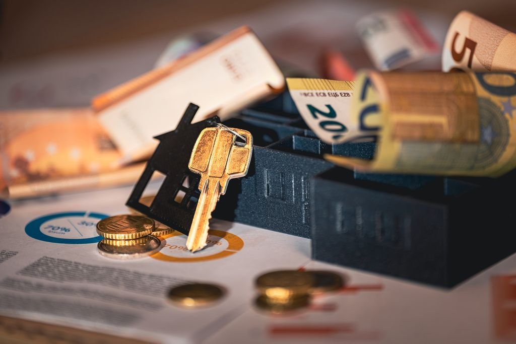 Model houses, keys and banknotes on financial charts