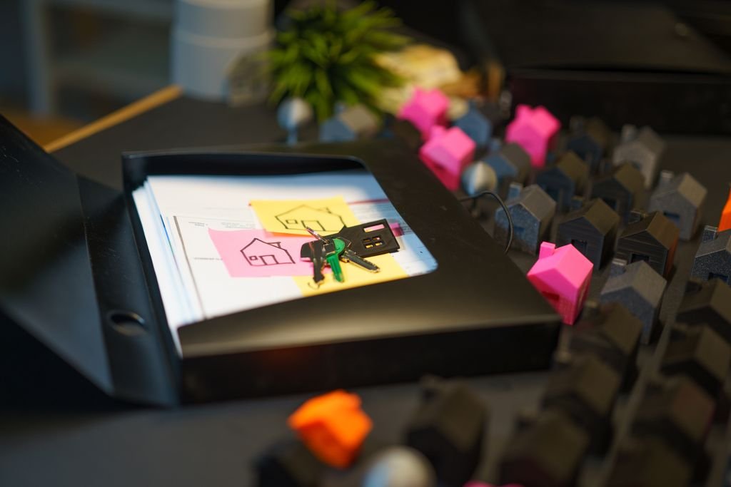 Secured vs. Unsecured Debt: What Is the Difference? Miniature houses beside a framed illustration on a desk