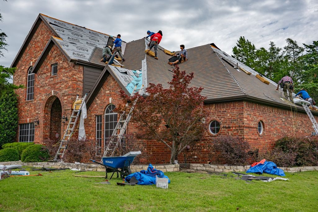 How to Get Insurance to Pay for Roof Replacement: 9 Claim Steps Workers replacing the roof of a brick house