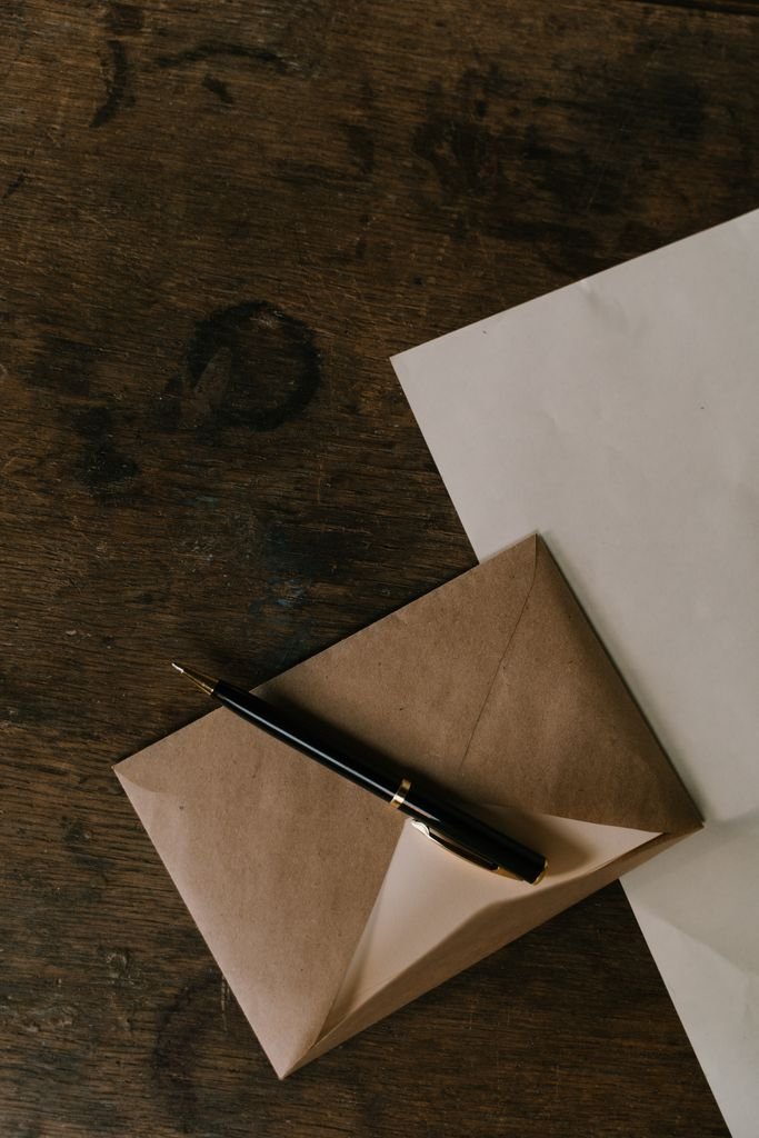 Debt Validation Letter: What to Include, When to Send and What Happens Next Brown envelope, black pen and white paper on a wooden table