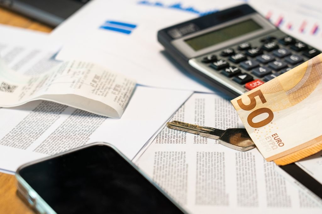 Debit Memo: Meaning, Bank Statement Examples and What to Check Calculator and euro banknote resting on financial documents