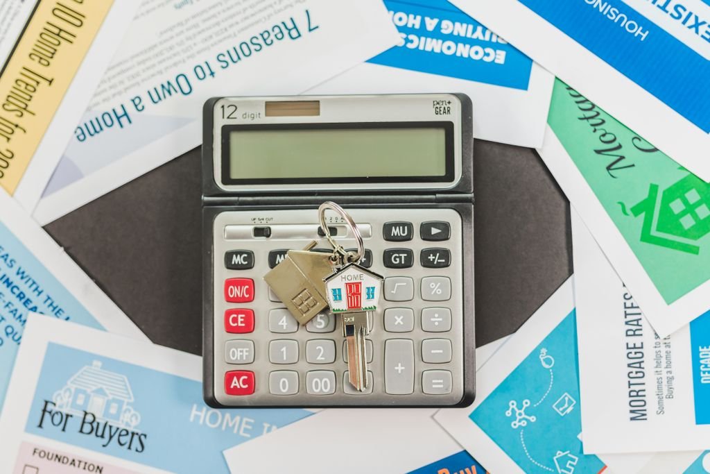Escrow Shortage: Why It Happens and What You Can Do Calculator and house key on real estate flyers