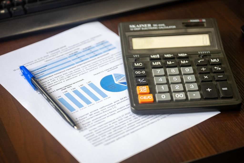 Accrued Interest: What It Means and How to Calculate It Calculator, pen and financial report on a wooden desk