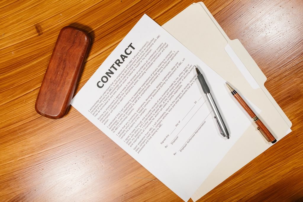 Twisting in Insurance: Meaning, Examples and Warning Signs Contract documents with two pens and a pen case on a wooden table