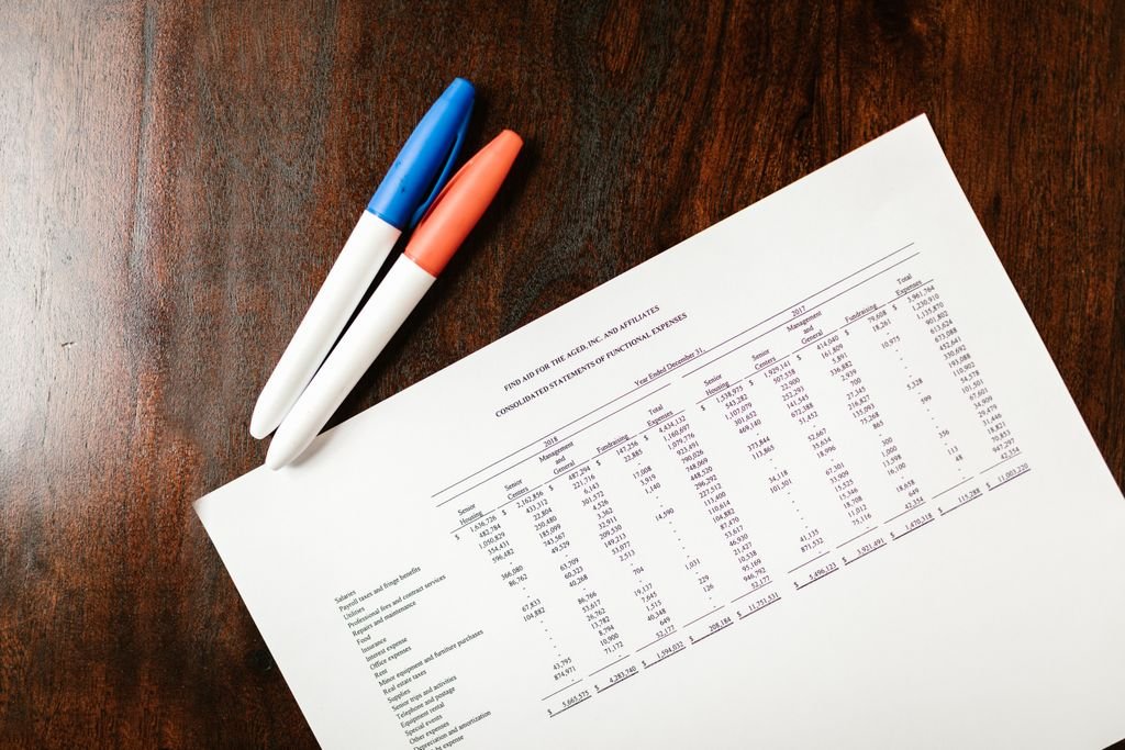 Diluted EPS: Meaning, Calculation and How It Differs From Basic EPS Financial statement and two colored pens on a wooden desk