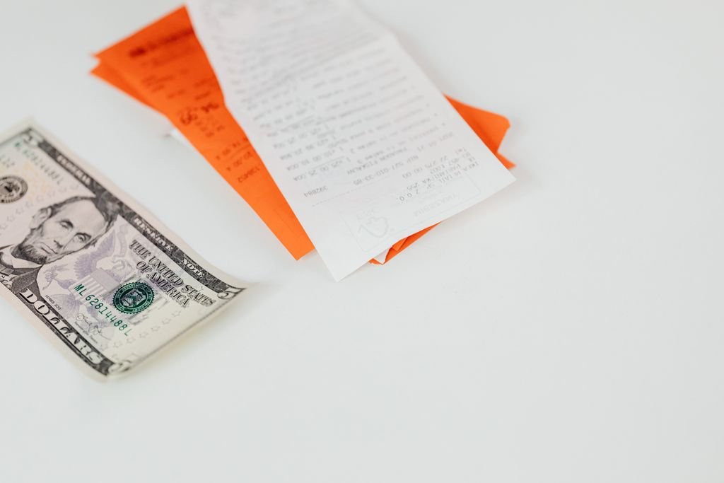 Escheatment: What Happens to Unclaimed Money and How to Recover It Five-dollar bill and receipts on a white surface