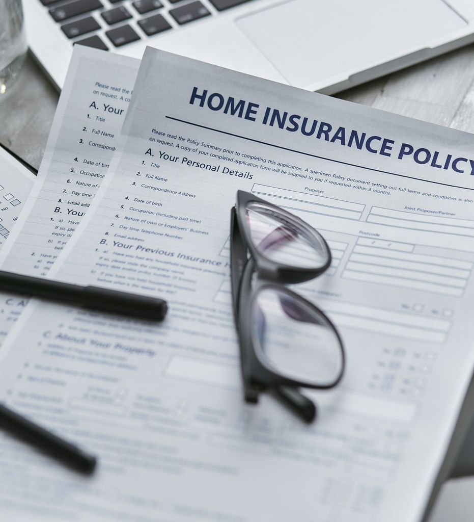 Insurance Endorsement: What It Is, Examples and How It Changes Coverage Home insurance policy documents with eyeglasses, pens and a laptop
