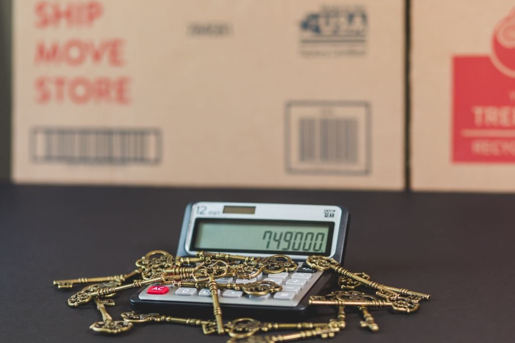 Escrow Refund: Why You Get One and When to Expect It House keys resting on a calculator beside a moving box