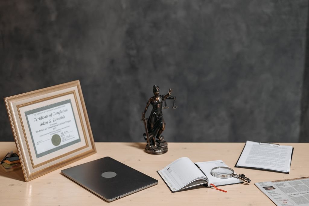 Trust Protector: Role, Powers and When You Might Need One Legal office desk with framed certificate, justice figurine, closed laptop and documents