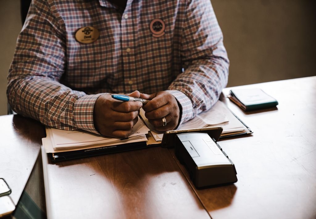 Restrictive Endorsement: What It Means and How to Use It on a Check Man holding a pen above paperwork and a notebook at a desk