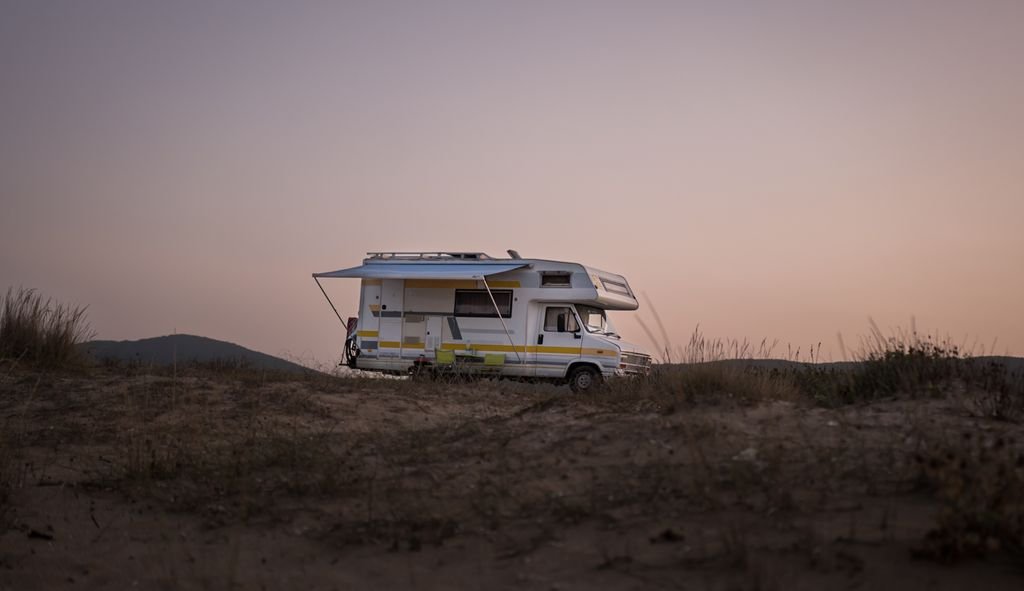 RV Insurance Cost: What Motorhome and Trailer Owners Pay Motorhome parked on open ground at sunset
