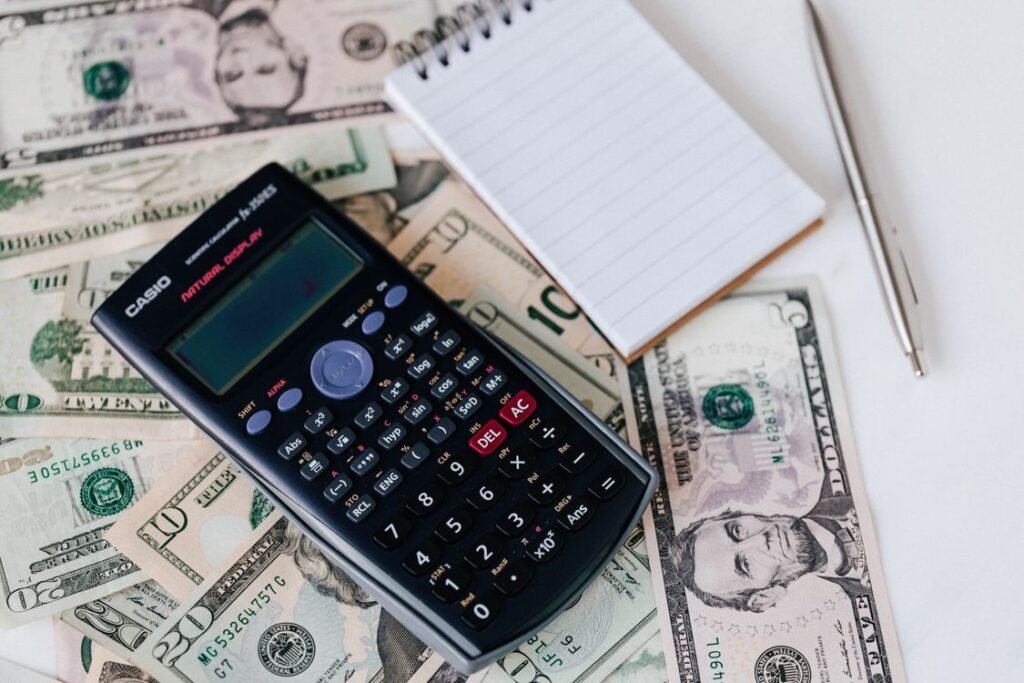 21 Sinking Fund Categories for a Smarter Budget Phone calculator, dollar bills and a notebook