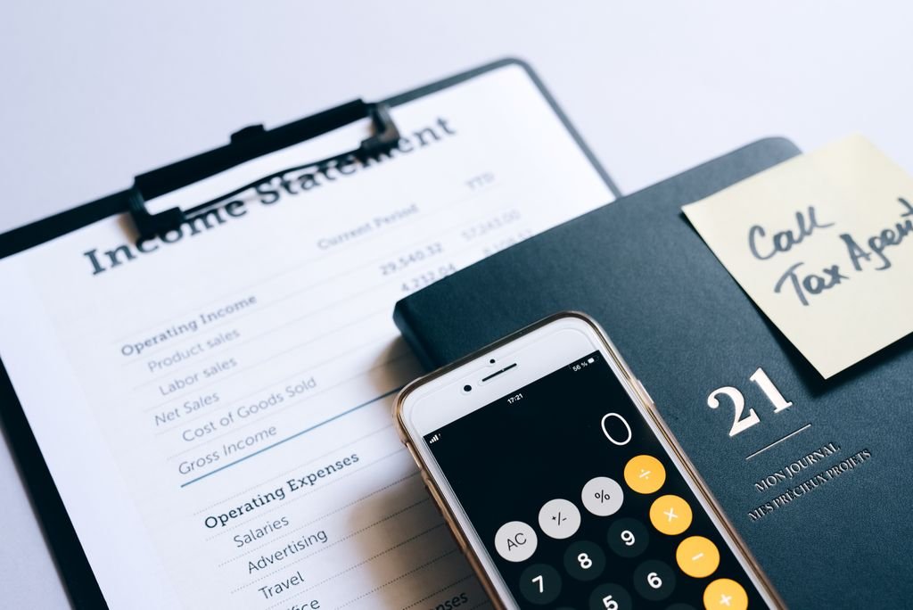 Smartphone calculator beside an income statement and planner