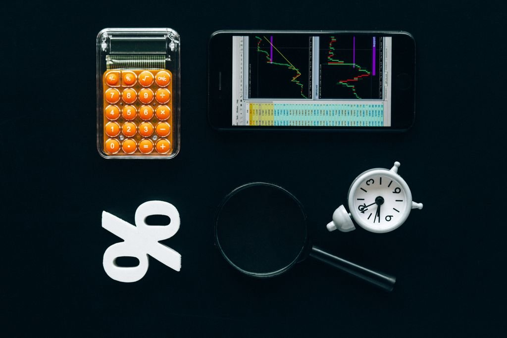 Yield to Worst: What It Means and How to Compare Bonds Calculator, smartphone charts, magnifying glass and clock on a black background
