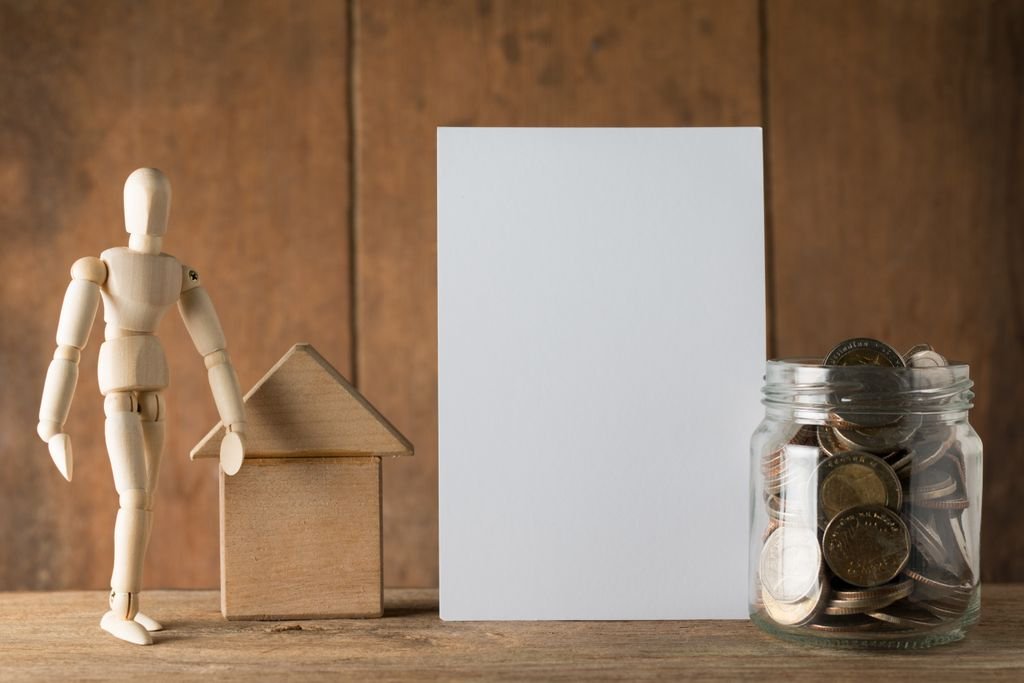 Business Money Market Account: How It Works and When to Use One Wooden figure beside a small wooden house and a blank white card