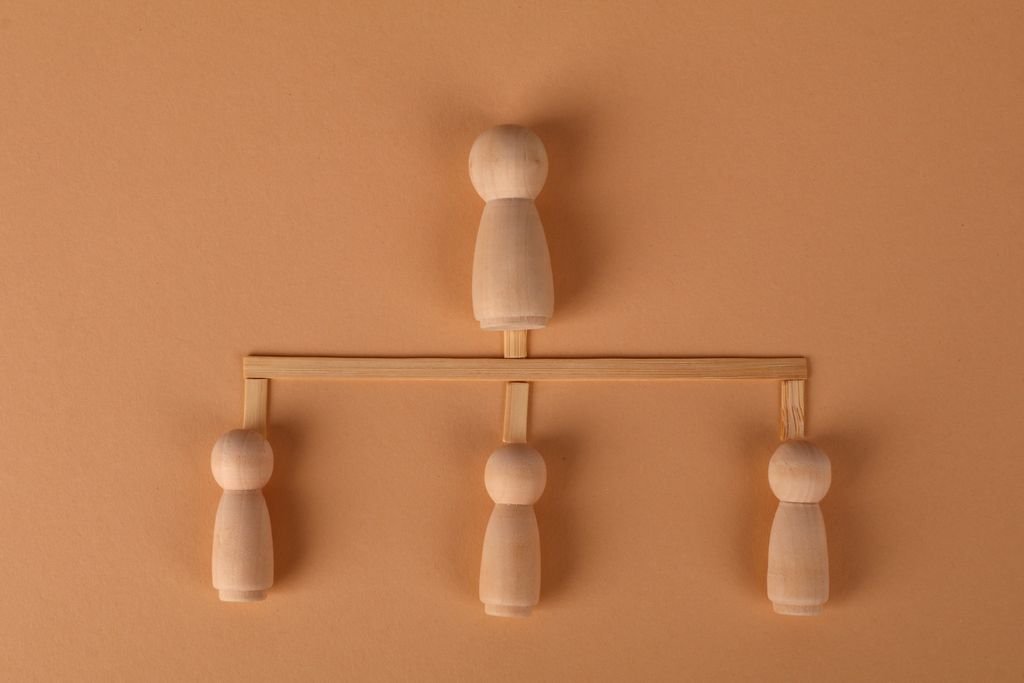 What Is an Estate? Assets, Debts and What Happens After Death Wooden figures arranged on a branching balance against a brown background