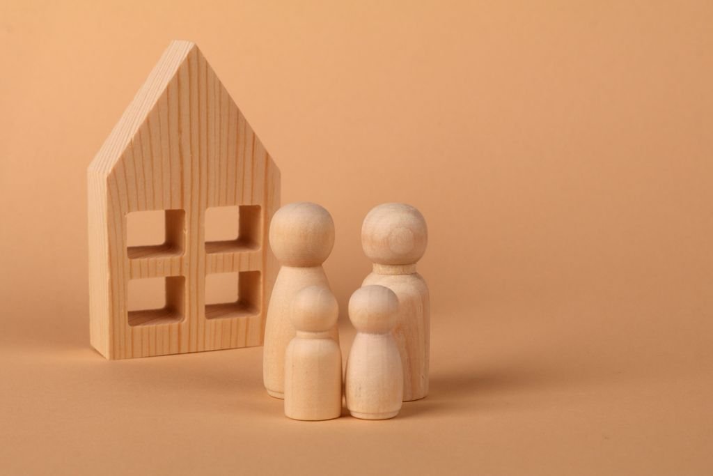 How to Put a House in a Trust: Steps, Costs and Mortgage Considerations Wooden house model and family figurines illustrating estate planning for a home